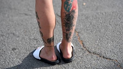 A fan bearing a tattoo of Barcelona's Argentinian forward Lionel Messi stands outside the player's home in Barcelona.