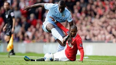 Manchester City’s Micah Richards barrels past Manchester United’s Ashley Young.