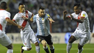 Argentina's Lionel Messi (C) is marked by Peru's Renato Tapia (R) and Victor Yotun during their 2018 World Cup qualifier football match in Buenos Aires on October 5, 2017. / AFP PHOTO / Alejandro PAGNI