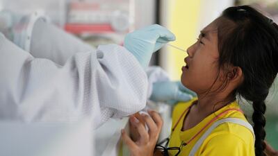 A healthcare worker takes a nasal swab sample from a person, as the country deals with a fresh wave of infections after tackling earlier outbreaks, in Bangkok, Thailand. Reuters