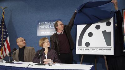 Members of Bulletin of the Atomic Scientists, watch as Lawrence Krauss, chair of the Bulletin of Atomic Scientists, and former ambassador Thomas R. Pickering, far right, unveil the 'Doomsday Clock' that remains at three minutes to midnight, during a news conference on January 26. Alex Brandon / AP Photo