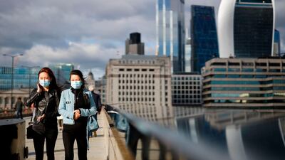 Pedestrians wear facemasks on London Bridge in central London on September 25. Tolga Akmen / AFP