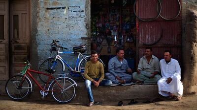 Palestinian refugees sit in front of a bicycle repair shop in Gezirat al-Fadel village, Sharqiya.