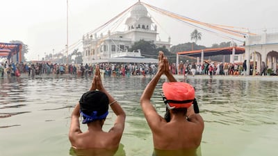 Sikh devotees gesture as they take a dip in a holy sarovar (water tank) on the occasion of the 550th birth anniversary of Guru Nanak Dev at Gurudwara Ber Sahib in Sultanpur Lodhi. AFP