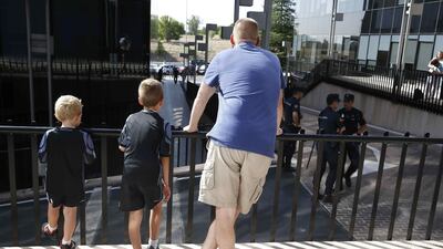 A man and two children wait outside Examining Magistrate's Court No 1, for the arrival of Portuguese footballer Cristiano Ronaldo, in the town of Pozuelo de Alarcon, outside Madrid. Paco Campos / EPA