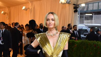 Model and actress Amber Valletta wearing a striking, gold gown. AFP