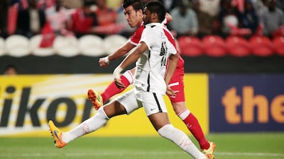 Tractor Sazi’s Bakhtiar Rahmani, in red, scores the only goal of the match in front of Al Jazira’s Fares Juma. Christopher Pike / The National