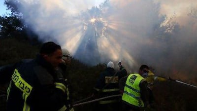 Israeli firefighters try to extinguish fire in the Carmel Forest near the northern city of Haifa as emergency teams, aircraft and equipment streamed in from other countries. Omer Messinger / AFP