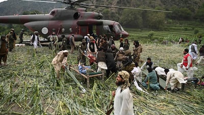 Rescue volunteers and Taliban security officers move the injured by military helicopter following a 6.0 magnitude earthquake in the Mazar Dara village of Nurgal, north-east of Jalalabad. AFP