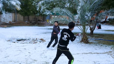 Iraqi boys play with snow in the holy Shiite city of Karbala on February 11, 2020. Mohammed Sawaf / AFP
