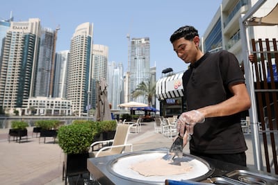 A man prepares ice cream in Dubai Marina. Most cities build and hope civility follows. Dubai is designing for it. Chris Whiteoak / The National