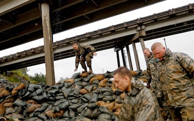 Members of the North Carolina National Guard finish stacking sand bags under a highway overpass. AP