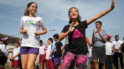 Children warm up with the help of their coach at the Infinity Games held at Sunmarke School Dubai. Leslie Pableo / The National