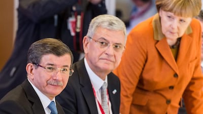 German Chancellor Angela Merkel, far right, stands up as EU leaders meet with Turkish prime minister Ahmet Davutoglu, far left, during an extraordinary summit of European Union leaders with Turkey in Brussels, Belgium on March 7, 2016. Geert Vanden Winjgaert/EPA