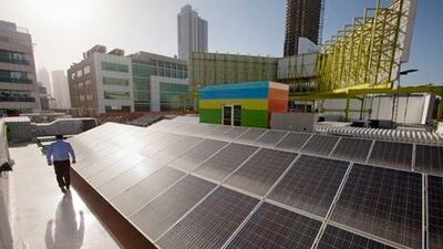 Gundeep Singh, the founder and chief executive of The Change Initiative, beside solar power units on the roof of his store. Jaime Puebla / The National