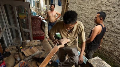 A gunsmith sands down a wooden rifle stock outside an air-rifle factory in Cipacing, Indonesia. Ed Wray / Getty Images