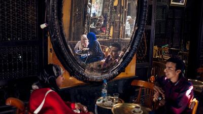 Young Egyptians are seen reflected in a mirror in the Al-Fishawy Cafe in Cairo, Egypt. Ed Giles / Getty Images