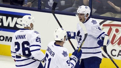 Toronto Maple Leafs players Dnaiel Winnik, left, Jake Gardiner, below, and Joffrey Lupul, right, celebrate a goal during their NHL win on Friday night. Paul Vernon / AP / October 16, 2015