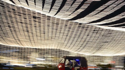 An auto rickshaw passes under Christmas lights in Colombo, Sri Lanka. AFP