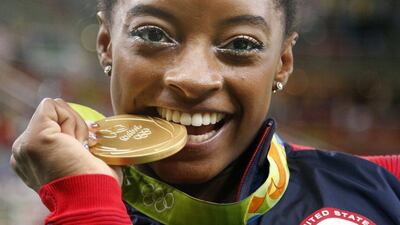 United States’ Simone Biles bites her gold medal for the women’s gymnastics individual all-around title at the 2016 Rio Olympics at Rio Olympic Arena on August 11, 2016 in Rio de Janeiro, Brazil. Dmitri Lovetsky / AP Photo