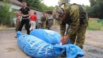 Policemen wrap up cannabis plants seized in a raid in the Chu Valley.