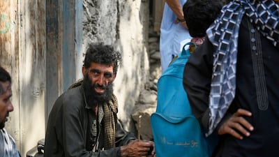 Villagers wait for assistance in the village of Wadir. AP