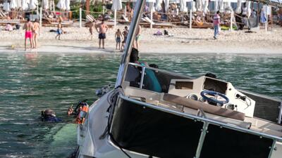 A sunken yacht being salvaged by its owner, Mohamed Irfan, and some volunteer divers off the beach on JBR. Antonie Robertson/The National