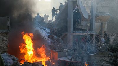 People and rescuers try to put out a fire at the site of an Israeli air strike that targeted a densely populated neighbourhood in Lebanon's eastern city of Baalbek. AFP