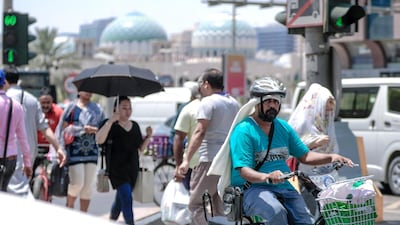 Pedestrians covered with "heat gear" in Abu Dhabi.