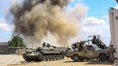 Smoke plume rise from an air strike behind a tank and pickup trucks mounted with gun turrets belonging to forces loyal to Libya's Government of National Accord, during clashes in the suburb of Wadi Rabie about 30 kilometres south of the capital Tripoli. AFP
