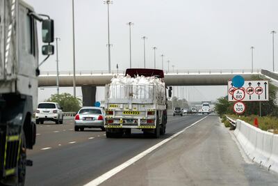 The new speed limit wrapped in blue plastic is displayed above the old speed limit. Victor Besa / The National