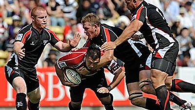 Hiroki Yuhara, of Japan, is tackled by Arabian Gulf players during their match in the Asian Five Nations tournament in Tokyo. Japan defeated Arabian Gulf 60-5.