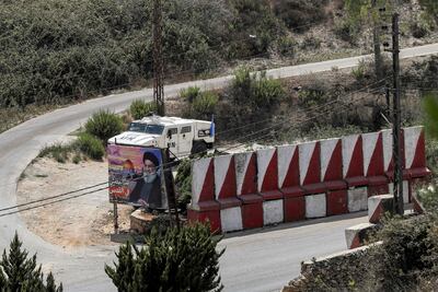 A Unifil vehicle behind a billboard of Hassan Nasrallah, leader of Lebanon's militant Shiite movement Hezbollah, imposed next to Jerusalem's Dome of the Rock shrine with a caption in Arabic reading 'we will pray in Jerusalem', in the southern Lebanese border village of Adaisseh on August 30, 2022. AFP