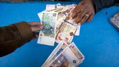 A customer changes Tunisian dinars for Libyan currency in Ben Garden. Lindsay Mackenzie.