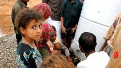Yemeni children gather near a water tank a camp for internally displaced people.