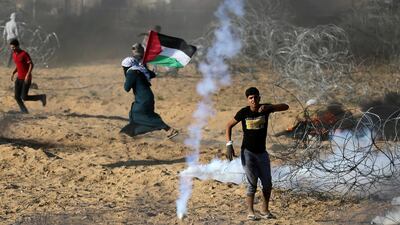 Palestinians react to tear gas fired by Israeli troops during a protest at the Israel-Gaza border in the southern Gaza Strip on July 13, 2018. Reuters