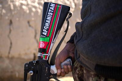 A soldier stands with a gun emblazoned with 'Afghanistan' at an outpost in Kandahar's Panjwayi district. Stefanie Glinski / The National