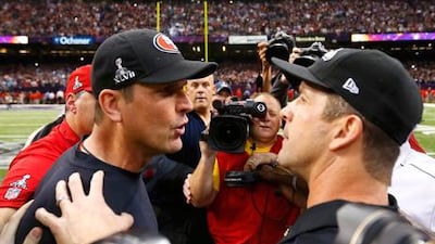 49ers coach Jim Harbaugh (l) congratulates his brother John (r) after Baltimore's Super Bowl victory.