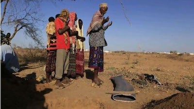 Men pray over the mat-wrapped body of 3-year-old Nasro Ahmed Gure, who died of illnesses related to malnutrition, as they prepare her for burial on the outskirts of Dagahaley Camp, Kenya, yesterday. UN refugee chief Antonio Guterres said that drought-ridden Somalia is the worst humanitarian disaster in the world.