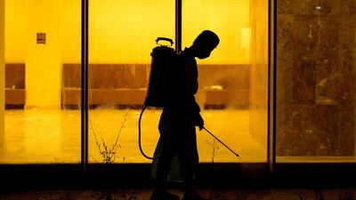 A medical staffer wearing PPE sterilises the entrance of an isolated section for the coronavirus disease treatment at a hotel in Basra. AFP