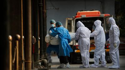 Health workers and relatives carry the body of a Covid-19 victim for cremation in New Delhi, India. AP