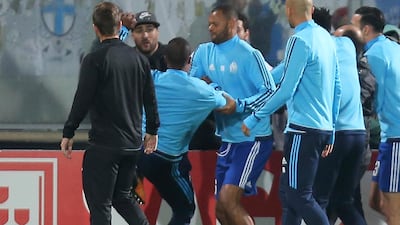 Marseille's Patrice Evra, third left with back to camera, raises his foot to lash out at a Marseile supporter during the warm-up before the Europa League game at Vitoria SC, an incident that led to the French defender being sent off. Luis Vieira / AP Photo