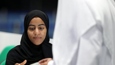 Emiratis register with election officials on Tuesday morning as early voting at Adnec gets under way at 9am. Chris Whiteoak / The National