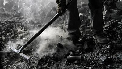 A worker spreads charcoal for cooling in the West Bank village of Yabed. The charcoal is made of citrus wood the workers say comes from Israel, and is later sold to Israelis and Palestinians for approximately 10 shekels (US$2.70) a kilo. Alaa Badarneh / EPA