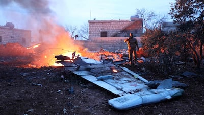 A rebel fighter takes a picture of a downed Russian Sukhoi-25 fighter jet in Syria's north-west province of Idlib on February 3, 2018. Russia and a war monitor said the pilot ehjected and was killed fighting with rebels.Omar Haj Kadour / AFP