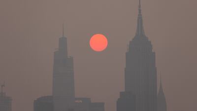Buildings in the Manhattan skyine shrouded in smoke from Canadian wildfires at sunrise in Jersey City, New Jersey. Bloomberg