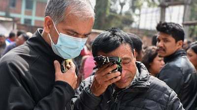 Family members of a plane crash victim react outside a morgue at the Teaching Hospital in Kathmandu on March 13, 2018, a day after the deadly crash of a US-Bangla Airlines plane at the international airport. Prakash Mathema / AFP