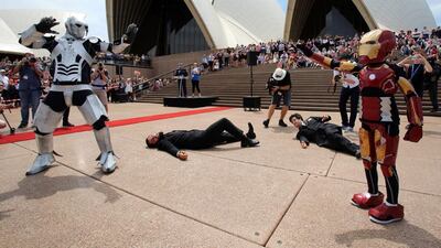 Nine-year-old Domenic Pace, right, acting out a scene as he is granted his wish to become a superhero like Iron Man, with police staging an elaborate event on the Sydney Opera House steps. AFP Photo / New South Wales Police