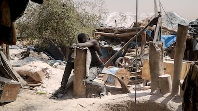 A worker rests his head on a wooden stump at a gold mine in Bouda, Burkina Faso. AP Photo
