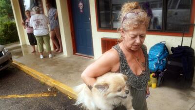 Lenora Adams loads up her dog as she evacuates a motel as Hurricane Michael comes ashore in Panacea, Florida. Reuters